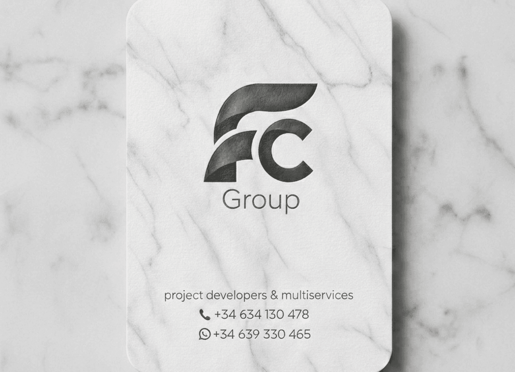 Marble business card for FC Group project developers, featuring a stylized logo and contact numbers.