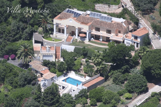 Aerial view of Villa Montaña, a large estate with a pool and lush tropical gardens.